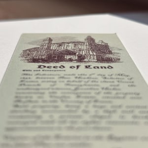 May include: A vintage deed of land document with an illustration of a building at the top. The text "Deed of Land" is centered, with smaller text below. The document has a sepia tone.