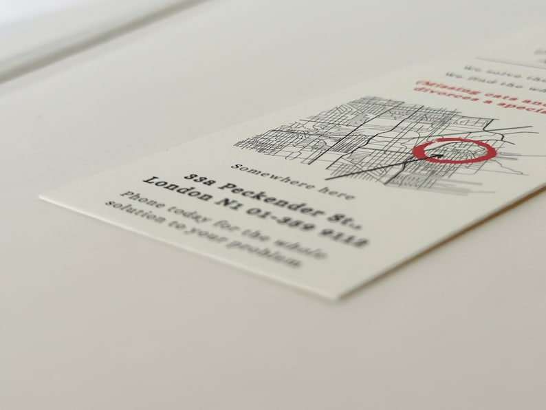 Op de afbeelding: Een witte visitekaartje met zwarte tekst die luidt: "Somewhere here 33a Peckender St. London N1 01-389 9112 Phone today for the whole solution to your problem". Een zwart-witte kaart met een rode cirkel op de achtergrond.