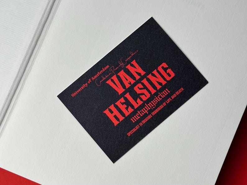 K&ouml;nnte beinhalten: Eine schwarze Visitenkarte mit rotem Text, der "VAN HELSING, Metaphysiker, Spezialist f&uuml;r obskure St&ouml;rungen des Lebens und des Todes" lautet. Die Karte enth&auml;lt auch den Text "Universit&auml;t von Amsterdam".