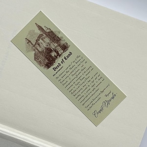 May include: A rectangular bookmark with the text "Deed of Land" and an illustration of a building. The bookmark is light green with brown text and illustration. The background is a light cream color.