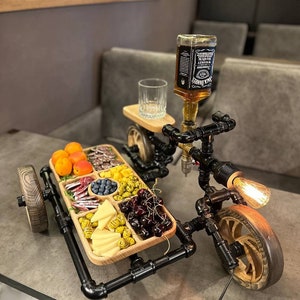 Vertedor de alcohol y otras bebidas con soporte para aperitivos. Un regalo original para cumpleaños y otras festividades.