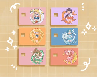 May include: Six colorful card designs featuring anime-style illustrations of Sailor Moon characters. Each card has a different background color and a unique character design, including Sailor Moon, Sailor Venus, and Sailor Mercury.