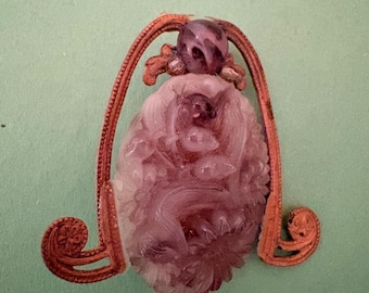 oval carved purple/lavender stone (likely amethyst quartz, dyed quartz, or lower-grade lavender jade/hardstone) featuring floral or foliage