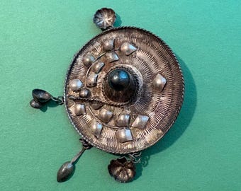 Ethnic/tribal-style silver-tone circular pendant or brooch
