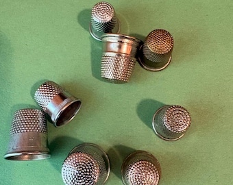 Lot of 8 vintage metal sewing thimbles (various sizes and styles).