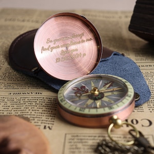 May include: A copper compass with a chain and a leather case. The compass face has a green and white design. The case has an engraved message: "So you can always find your way home to me. Love you 19.06.2024"