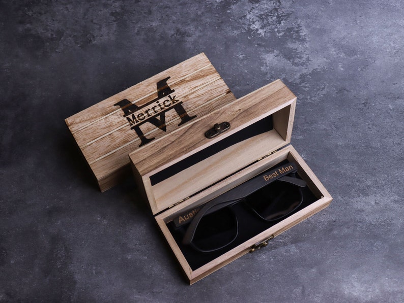 May include: A wooden box with a personalised inscription "Merrick M" on the lid. The box is open and contains a pair of black sunglasses with the inscription "Best Man" on the frame.