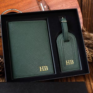 K&ouml;nnte beinhalten: Ein gr&uuml;nes Leder-Reisepass-Etui und ein Gep&auml;ckanh&auml;nger-Set mit goldenen Initialen "HB".