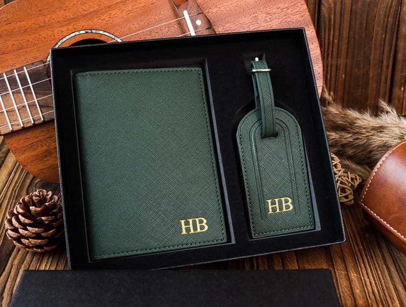 K&ouml;nnte beinhalten: Ein gr&uuml;nes Leder-Reisepass-Etui und ein Gep&auml;ckanh&auml;nger-Set mit goldenen Initialen "HB".