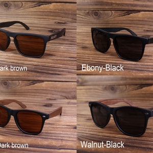 May include: Four pairs of sunglasses with wooden arms. The sunglasses have black frames and either dark brown or black lenses. The wooden arms are either ebony or walnut.