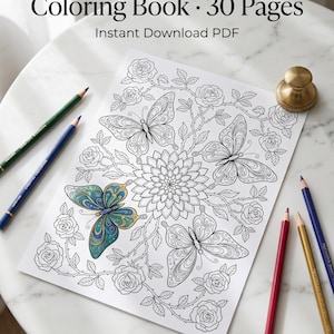 May include: A coloring book page with a floral and butterfly design, partially colored with blue and gold. The page is surrounded by colored pencils and a gold-colored paperweight. Text at the top reads "Nature Mandala Coloring Book &bull; 30 Pages".