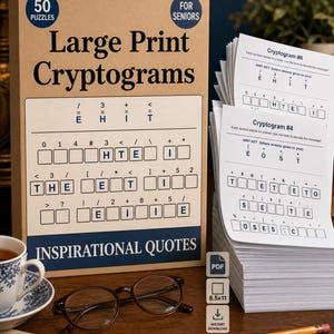 May include: A box set of "Large Print Cryptograms" puzzles for seniors, with "Inspirational Quotes" text. Includes a stack of puzzle sheets, a cup of tea, glasses, a pencil, and a newspaper on a wooden surface.