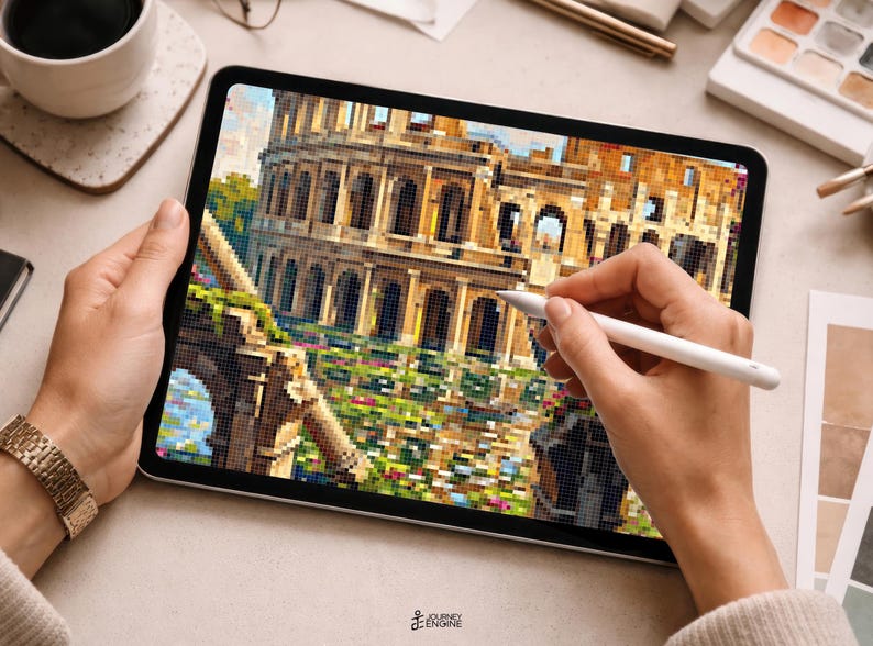 May include: A digital tablet displaying a pixelated illustration of the Roman Colosseum. The screen shows the ancient stone amphitheater with arched levels and a foreground of green foliage and colorful flowers. A white stylus is held against the screen.