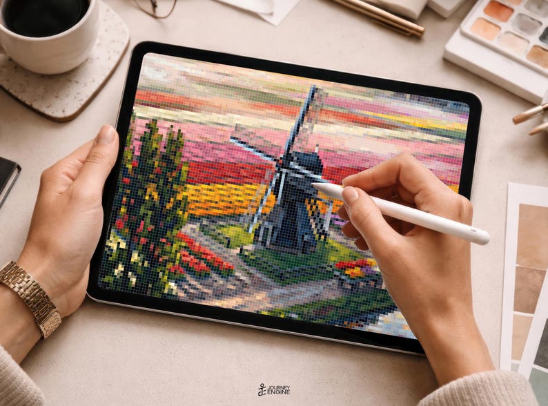 May include: A digital tablet displaying a pixelated landscape illustration featuring a dark windmill, a tall green tree, and a vibrant sunset sky with horizontal bands of pink, orange, and yellow colors, rendered in a distinct blocky mosaic style.