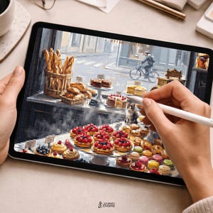 May include: A digital tablet displaying a pixel art illustration of a bakery scene. The screen shows a variety of pastries, including red-topped tarts and golden baguettes in a basket, with a street view featuring a cyclist in the background.