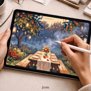 May include: A tablet displaying a pixel art illustration of a picnic table with a bouquet of flowers under trees, being edited with a white stylus. The screen shows a vibrant landscape with orange, blue, and green square pixels and a logo at the bottom.