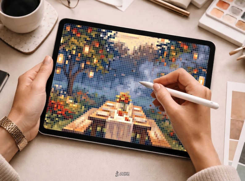 May include: A tablet displaying a pixel art illustration of a picnic table with a bouquet of flowers under trees, being edited with a white stylus. The screen shows a vibrant landscape with orange, blue, and green square pixels and a logo at the bottom.