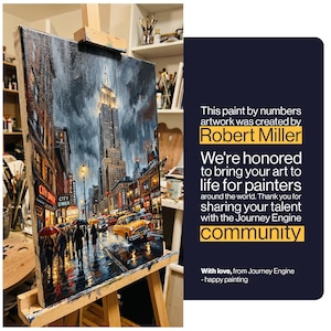 May include: A paint by numbers canvas on a wooden easel depicting a rainy New York City street scene with the Empire State Building, a yellow taxi, and pedestrians with umbrellas. Text reads: This paint by numbers artwork was created by Robert Miller.