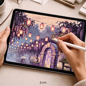 May include: A digital tablet displaying a pixel art illustration of a stone archway surrounded by purple foliage and glowing lanterns. The screen shows a detailed scene with warm light sources and a small figure holding an umbrella, rendered in a grid-based style.