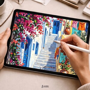 May include: A digital tablet displaying a pixelated art illustration of a Mediterranean street scene with vibrant pink bougainvillea, a blue door, and stone steps. The screen shows a colorful mosaic-style image being edited with a white stylus.