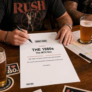 以下が含まれることがあります： Journey Engine Chapter 1 The 1980s The MTV Eraというタイトルの白い紙の文書。ヘアメタル、ニューウェーブ、ミュージックビデオの革命に関するテキストと372の質問が記載されており、ペンやトリビア関連の資料と共に木製のテーブルの上に置かれています。