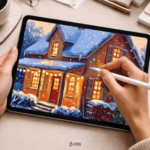 May include: A tablet displaying a pixel art illustration of a house covered in snow with glowing yellow windows and a red door. The screen shows a winter scene with blue and white tones, while a white stylus is held against the digital display.