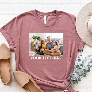 May include: A mauve t-shirt with a photo of a family of four smiling and sitting on a couch. The text "YOUR TEXT HERE" is printed below the photo.