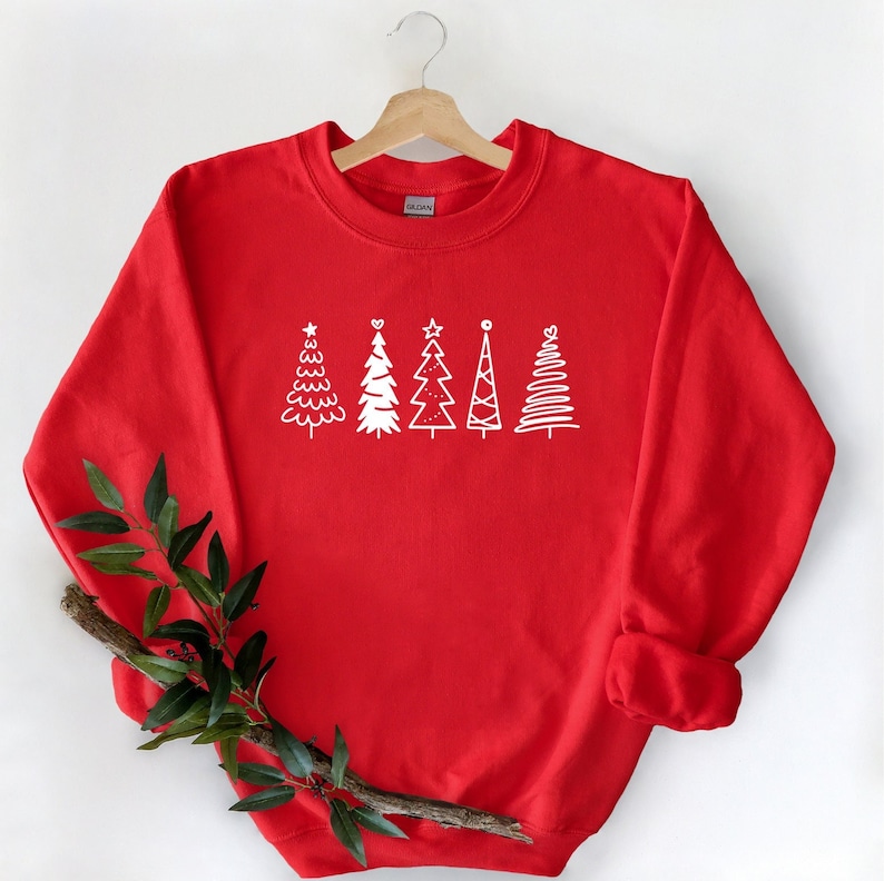 May include: Red Christmas sweatshirt with a white design of five stylized Christmas trees.