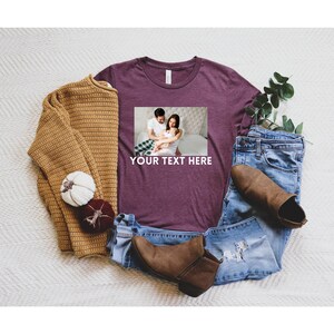 May include: A maroon t-shirt with a photo of a family of three on the front. The text "YOUR TEXT HERE" is printed below the photo.