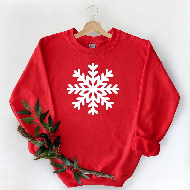 May include: Red sweatshirt with a white snowflake design.