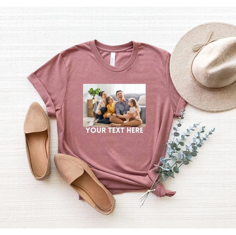 May include: A mauve t-shirt with a photo of a family of four smiling and sitting on a couch. The text "YOUR TEXT HERE" is printed below the photo.