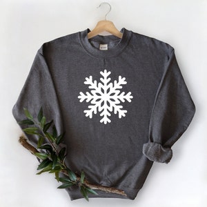 May include: A dark gray sweatshirt with a white snowflake design on the front.