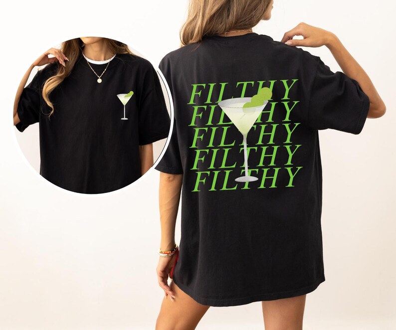 May include: Black t-shirt featuring a lime green martini glass graphic on the front and back. The back of the shirt has the word "FILTHY" repeated in a stacked design with a martini glass graphic. The shirt is a casual, oversized style.