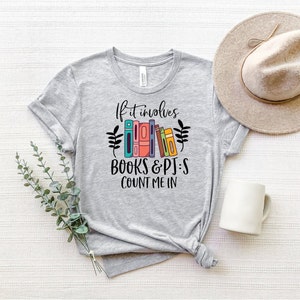 May include: A heather grey t-shirt with the text "If it involves books & pjs count me in" and a graphic of colorful books.