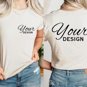May include: A cream-coloured short-sleeved t-shirt featuring the text "Your Design" in a black script font on the front and back. The shirt is made of a soft material, suitable for custom designs.