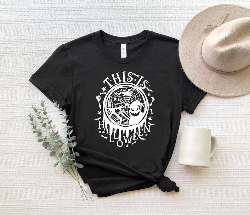 May include: Black t-shirt with a white graphic design featuring a spider web, a ghost, and the text "This is Halloween Love".
