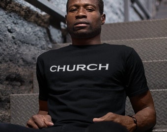 Puede incluir: Un hombre con una camiseta negra con la palabra "CHURCH" impresa en blanco en la parte delantera. Está sentado en un tramo de escaleras de hormigón.