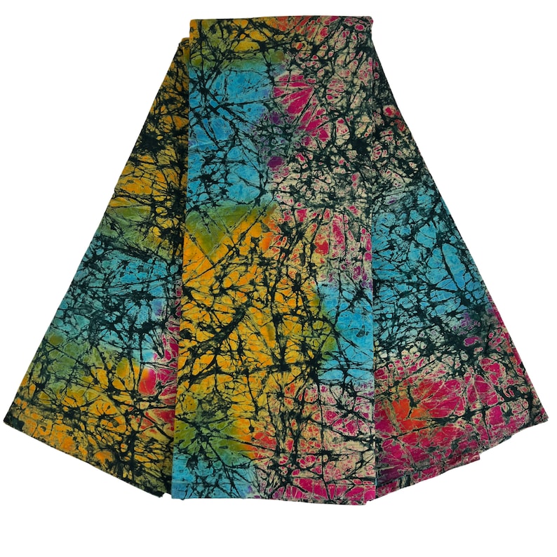 Puede incluir: Una pila de tres cuadrados de tela con un patr&oacute;n batik en tonos de azul, amarillo, rosa y verde. La tela tiene un dise&ntilde;o craquelado negro.