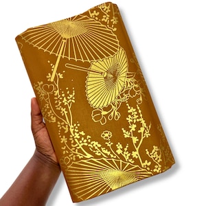 Può includere: Un pezzo di tessuto rettangolare di colore giallo senape intenso con una stampa in lamina d'oro metallizzata. Il motivo è composto da ombrelli in stile giapponese tradizionale e delicati rami di ciliegio sparsi sulla superficie.