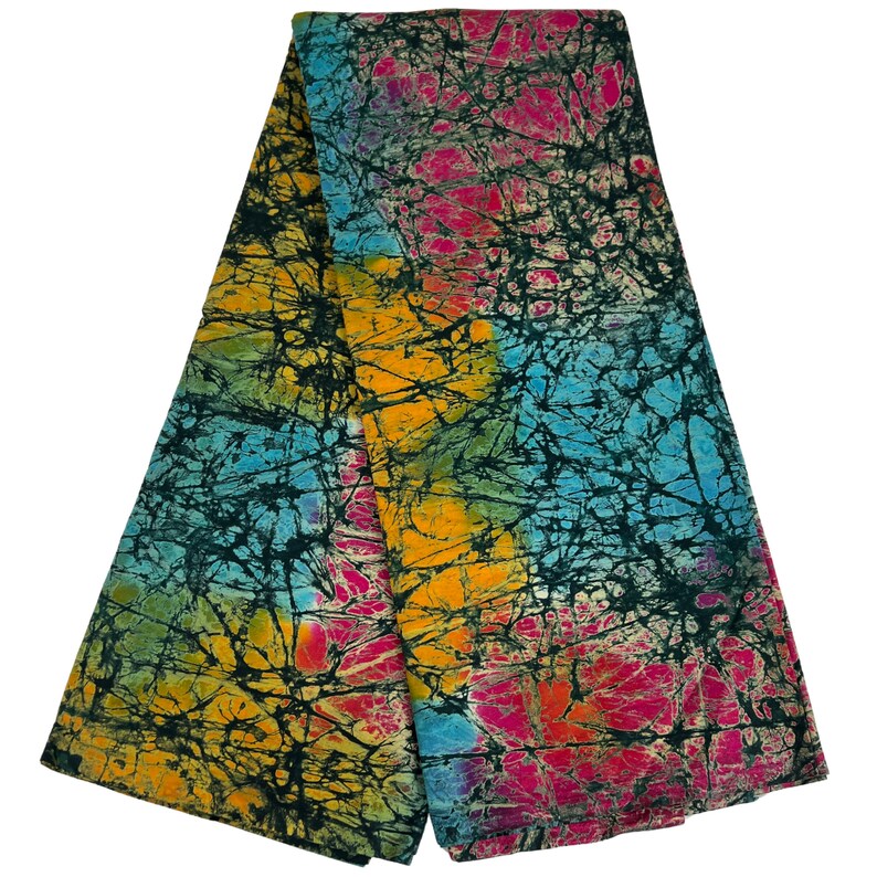 Puede incluir: Una tela batik colorida con fondo negro y un patr&oacute;n de l&iacute;neas azules, amarillas, rosas y verdes. La tela est&aacute; doblada por la mitad.