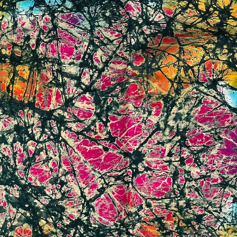 Puede incluir: Tela batik abstracta con un patr&oacute;n negro, blanco, rosa y naranja. La tela tiene un aspecto texturizado y te&ntilde;ido a mano.