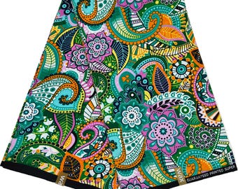 May include: A colourful fabric with a paisley pattern in shades of green, orange, pink, and blue. The fabric has a white background and features a repeating pattern of paisley shapes, flowers, and leaves. The fabric is labelled "WAX GUARANTEED PRINTED SUPER".