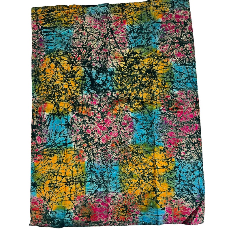 Puede incluir: Una tela colorida con un patr&oacute;n batik en tonos de azul, amarillo, rosa y verde. La tela tiene un fondo negro con un efecto craquelado.