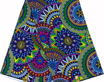 Könnte beinhalten: Ein farbenfroher Stoff mit einem sich wiederholenden Muster aus blauen, grünen, gelben und rosa Kreisen und geometrischen Formen.