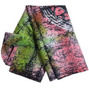 May include: A folded fabric featuring a batik-style pattern with vibrant gradients of lime green and soft pink. The surface is overlaid with a dark, intricate black crackle texture that creates a web-like appearance across the entire textile.