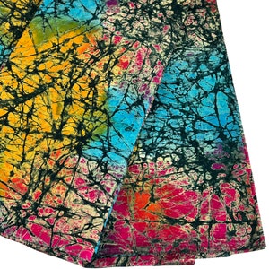 Puede incluir: Una tela colorida con un patr&oacute;n batik en tonos de azul, amarillo, rosa y negro. La tela tiene un efecto tie-dye y est&aacute; hecha de un material suave y ligero.