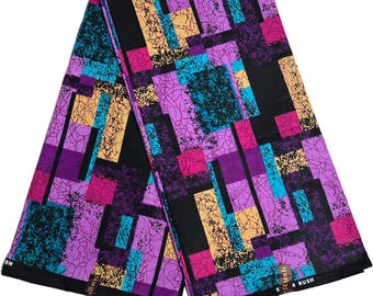 May include: A purple, pink, blue, and yellow geometric patterned fabric with a black background. The fabric has a textured look and the pattern is made up of squares and rectangles. The fabric is folded in half and the edges are visible. The fabric has the text "S.R. RUSH" printed on the bottom right corner.
