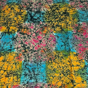 Puede incluir: Una tela colorida con un patr&oacute;n batik en tonos de azul, amarillo, rosa y negro. La tela tiene un efecto tie-dye con un dise&ntilde;o de remolino.