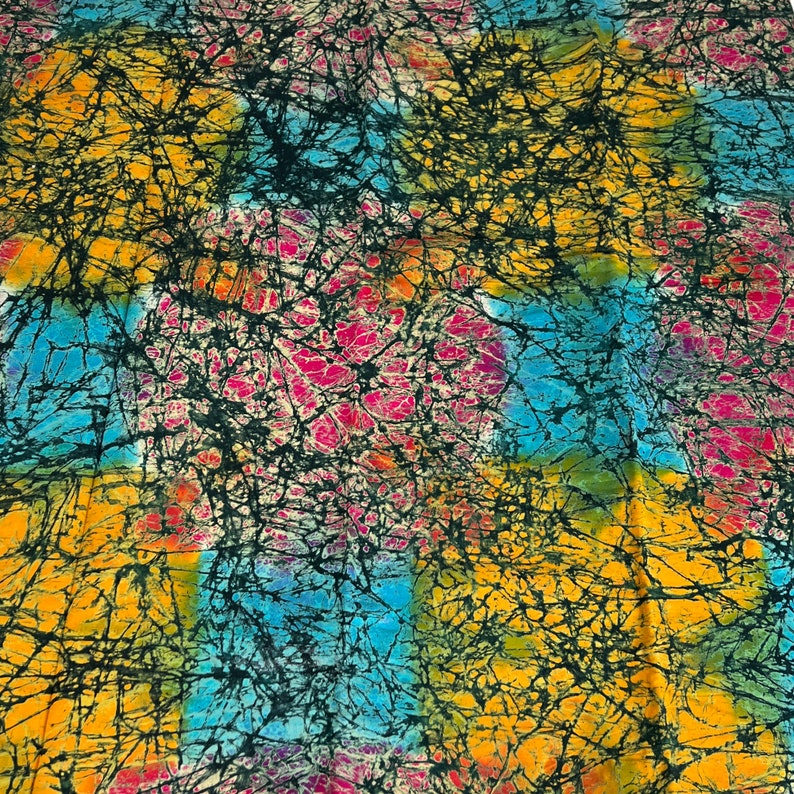 Puede incluir: Una tela colorida con un patr&oacute;n batik en tonos de azul, amarillo, rosa y negro. La tela tiene un efecto tie-dye con un dise&ntilde;o de remolino.
