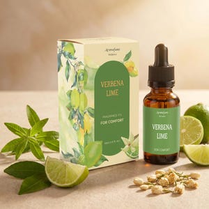 May include: AromaFume Verbena Lime fragrance oil bottle and box. The amber glass bottle has a black dropper. The box and label feature green text and a lime and leaf design. The box reads "Fragrance Oil For Comfort". Limes and flowers are also present.